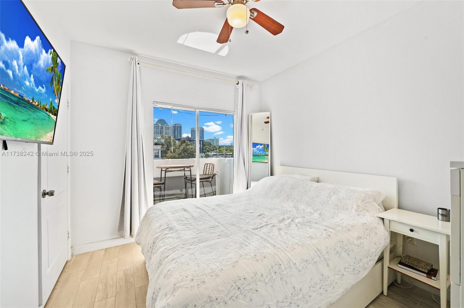 3051 Southwest 27th Avenue, Unit 302 Miami, FL 33133 - Photo 9 of 19 a spacious bedroom with a bed and a flat screen tv