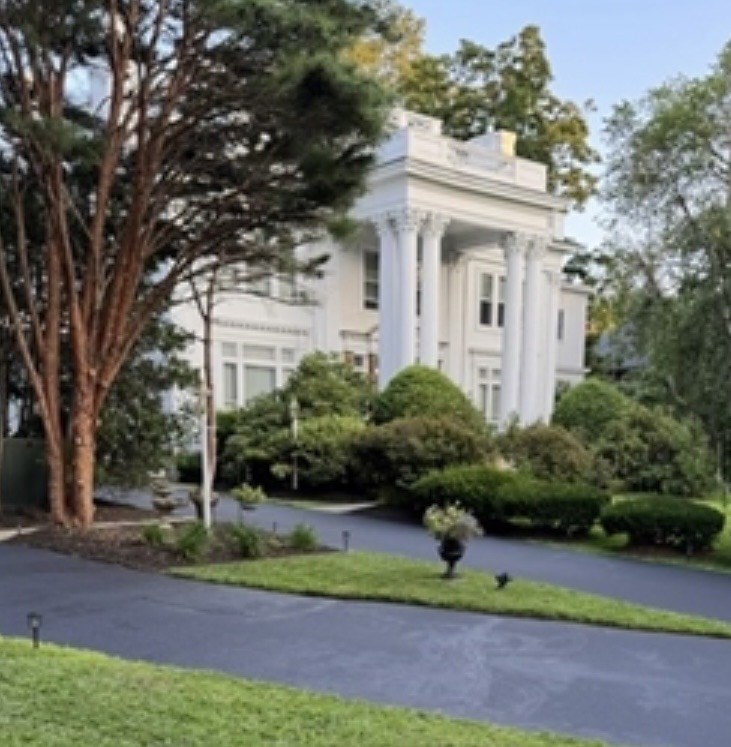 a front view of a house with a yard and potted plants