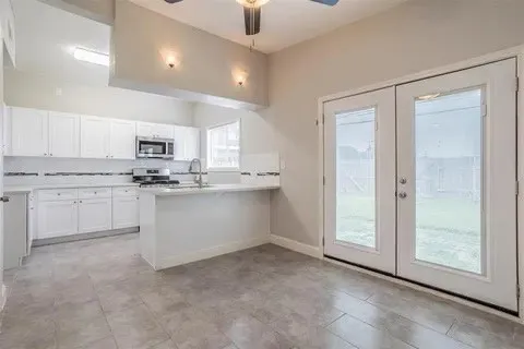 a kitchen with white cabinets appliances and a sink