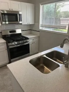 a kitchen with a sink and a stove top oven