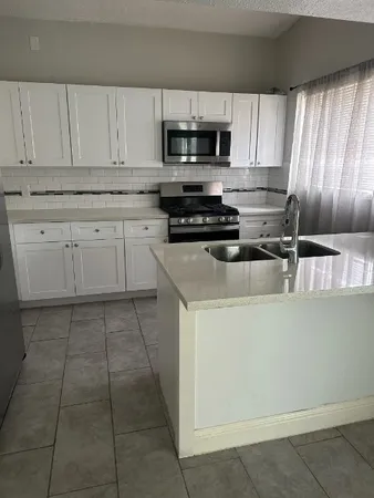 a kitchen with cabinets appliances and a window