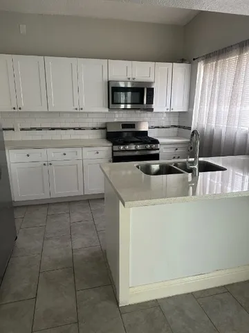 a kitchen with cabinets appliances and a window
