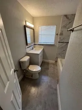 a bathroom with a toilet sink and mirror