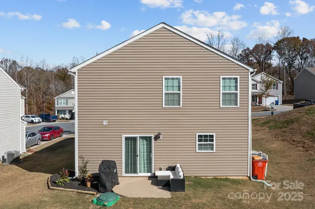 a view of backyard with seating space and a large tree