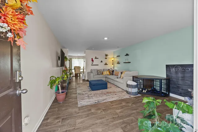 a living room with furniture a flat screen tv and a large window