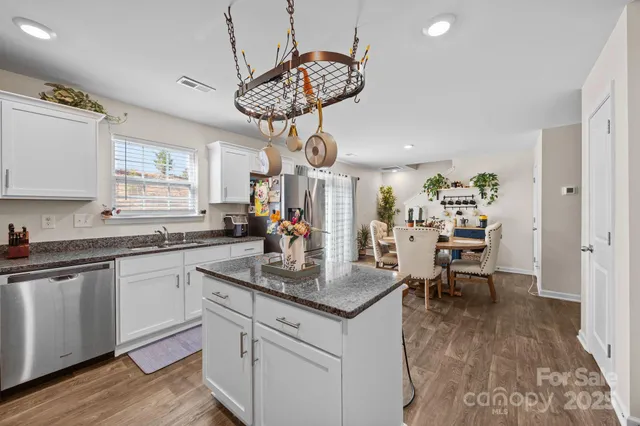a kitchen with granite countertop a sink window and cabinets