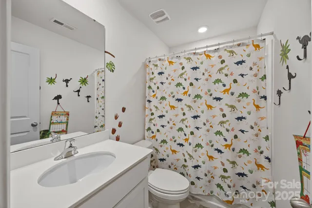 a bathroom with a double vanity sink toilet and mirror