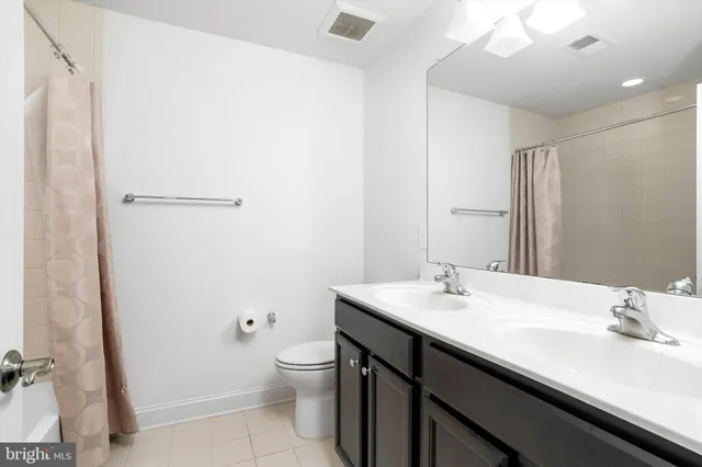 a bathroom with a sink a toilet a mirror and shower