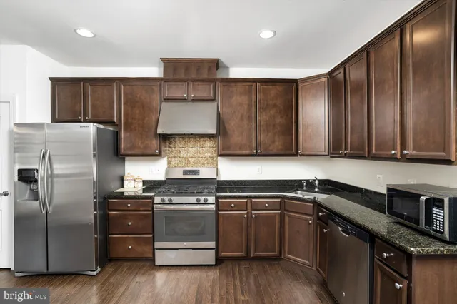 a kitchen with a sink a refrigerator and cabinets