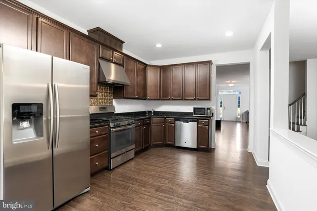 a kitchen with stainless steel appliances granite countertop a refrigerator stove and oven
