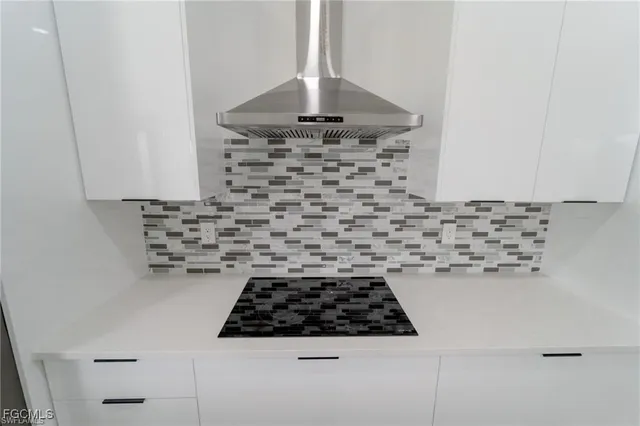 a kitchen with a stove a white cabinet and a granite counter top
