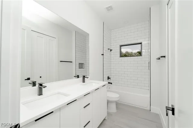 a bathroom with a double vanity sink mirror and shower