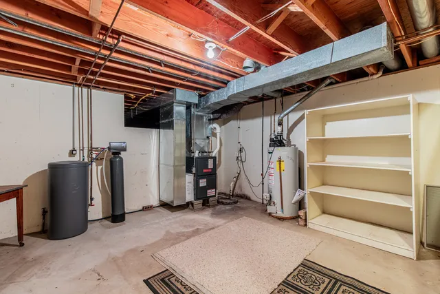 an empty room with chandelier fan and windows
