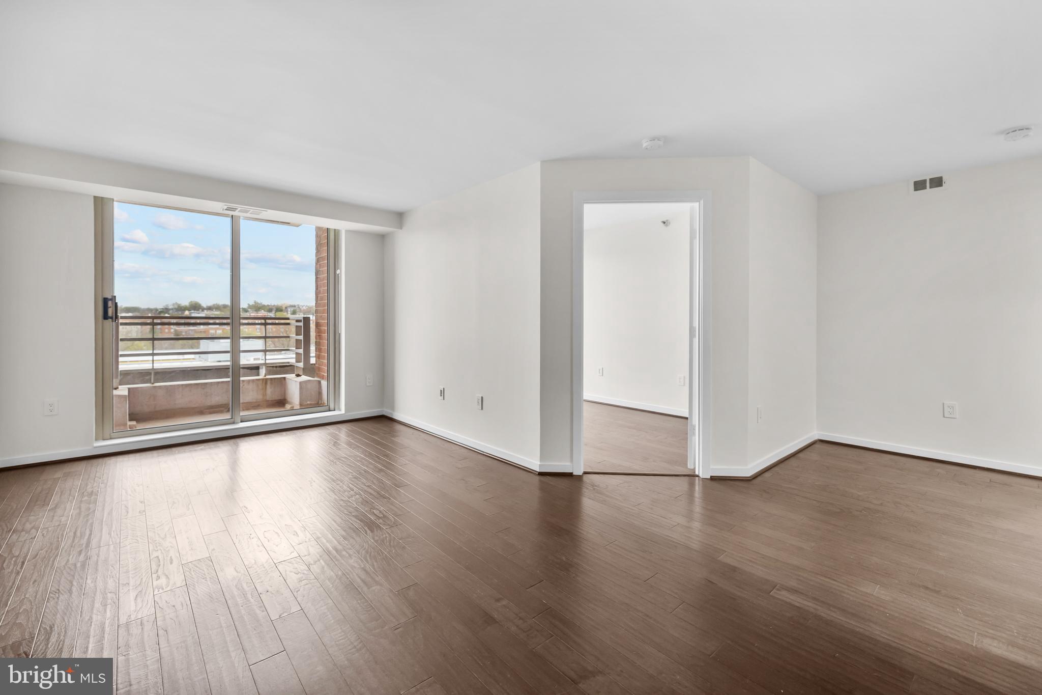 1275 25th Street Northwest, Unit 701 Washington, DC 20037 - Photo 12 of 36 a view of an empty room with wooden floor and a window