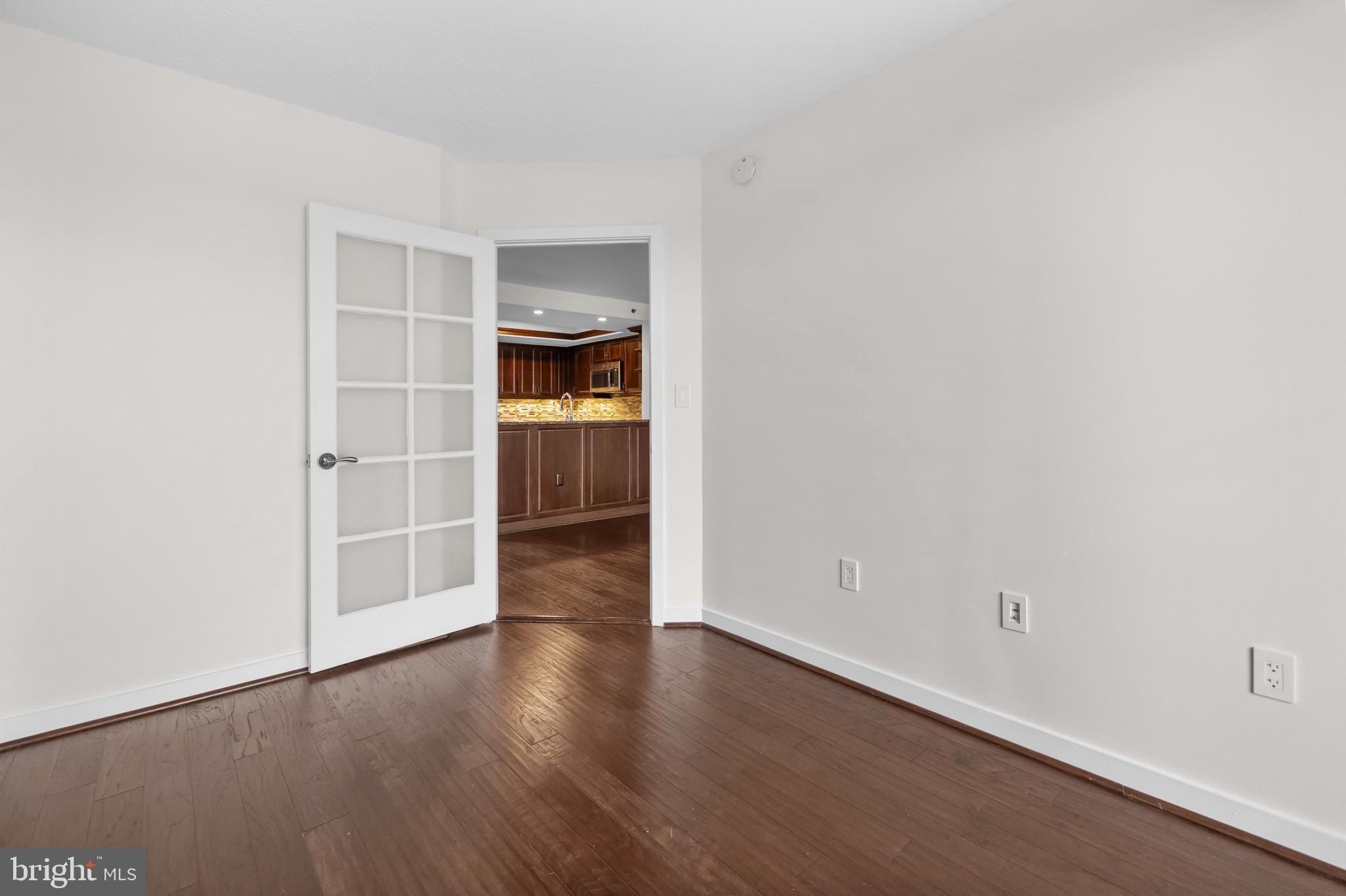 1275 25th Street Northwest, Unit 701 Washington, DC 20037 - Photo 14 of 36 a view of a room with wooden floor and white walls