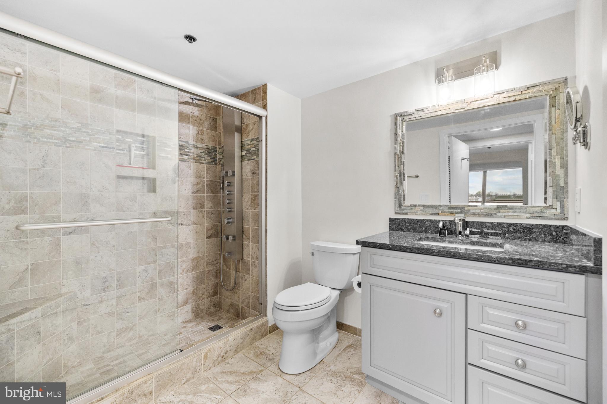 1275 25th Street Northwest, Unit 701 Washington, DC 20037 - Photo 19 of 36 a bathroom with a granite countertop sink a toilet and a mirror