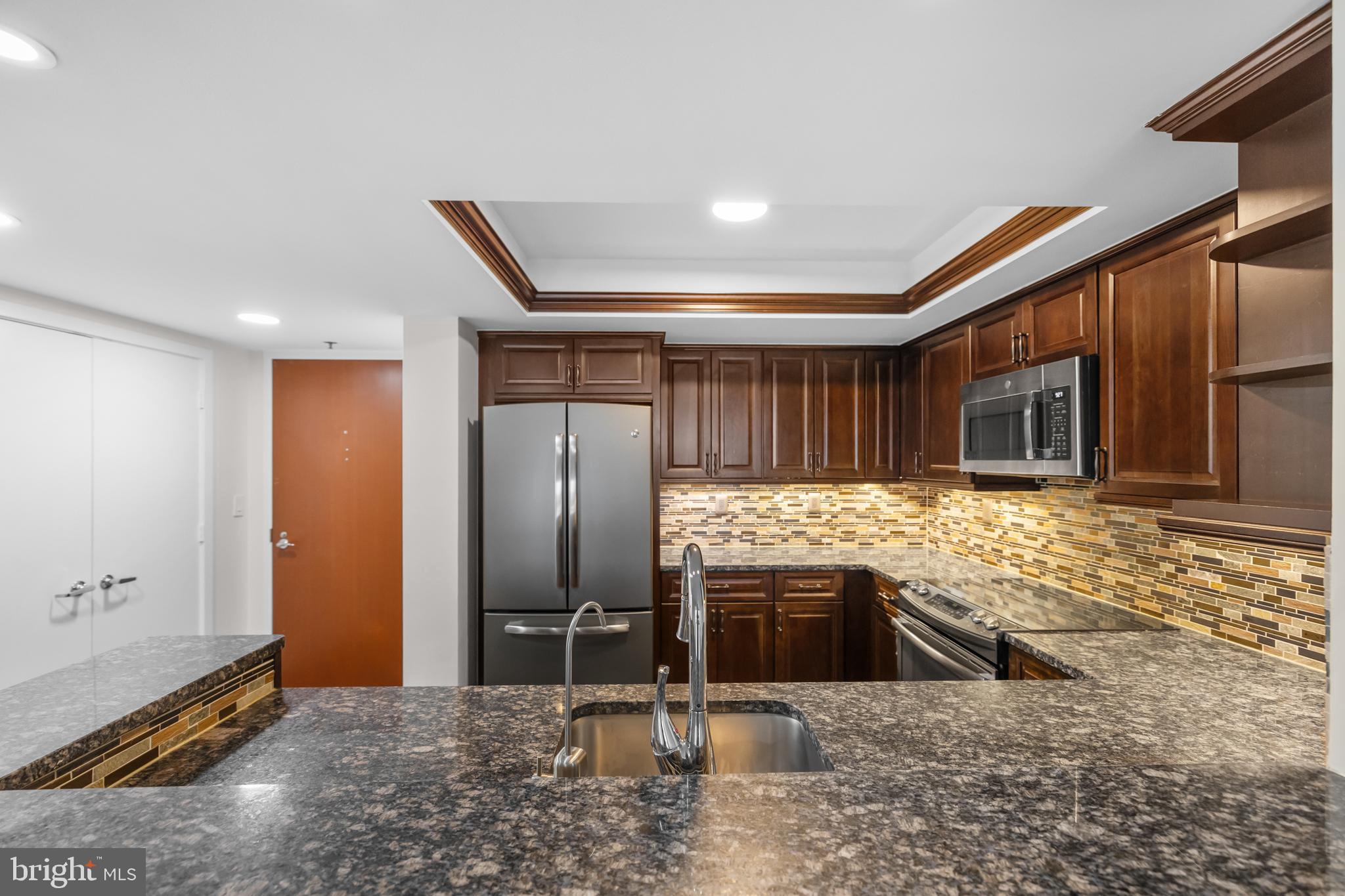 1275 25th Street Northwest, Unit 701 Washington, DC 20037 - Photo 4 of 36 a kitchen with stainless steel appliances granite countertop a sink and a refrigerator