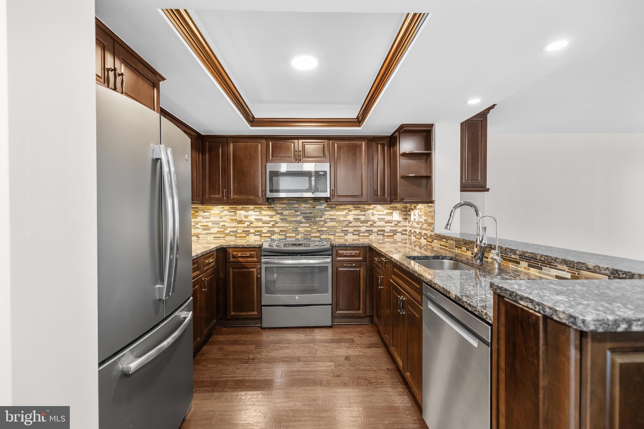 1275 25th Street Northwest, Unit 701 Washington, DC 20037 - Photo 5 of 36 a kitchen with stainless steel appliances granite countertop a sink and stove top oven