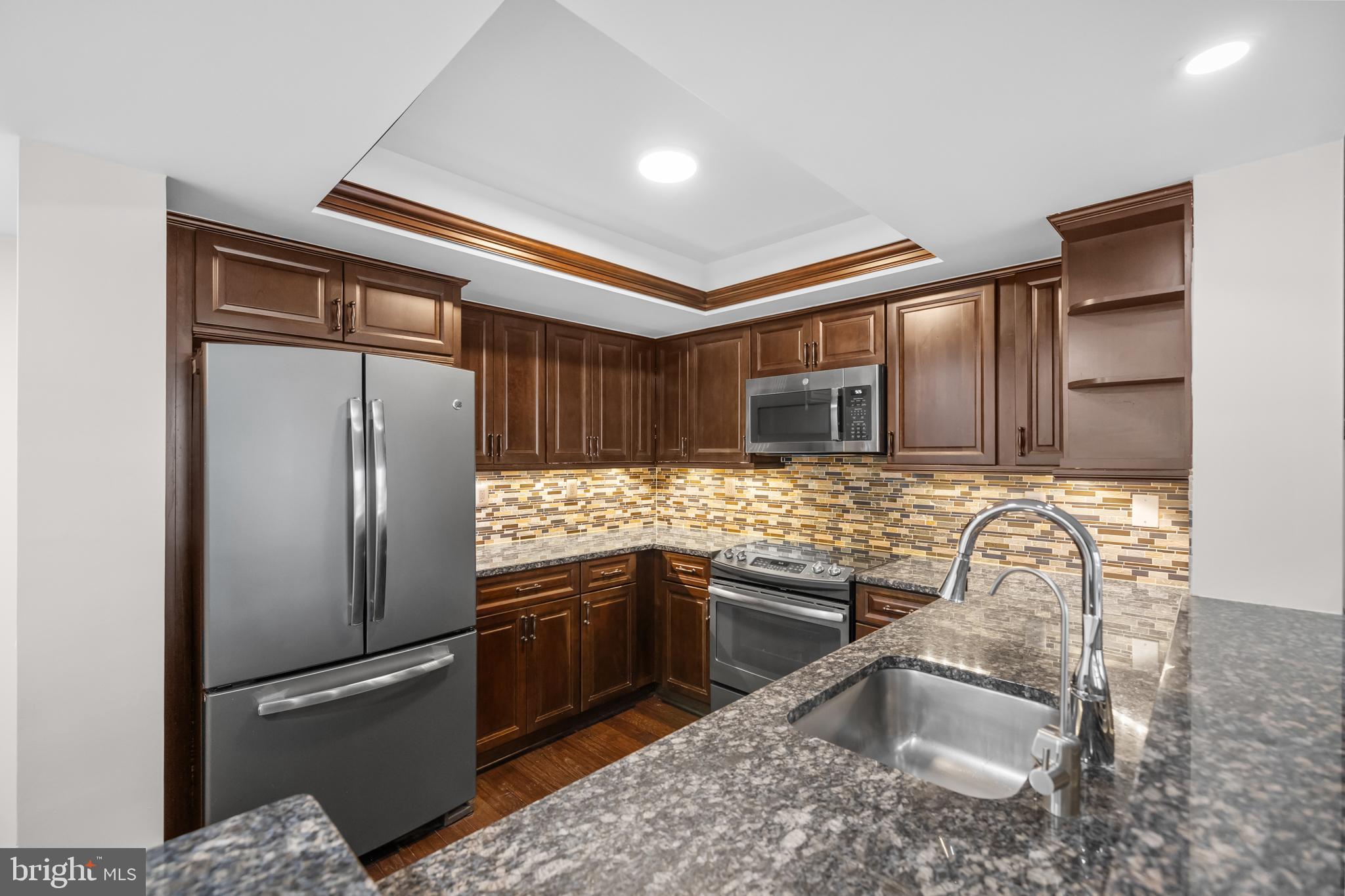 1275 25th Street Northwest, Unit 701 Washington, DC 20037 - Photo 6 of 36 a kitchen with granite countertop stainless steel appliances a refrigerator and a sink