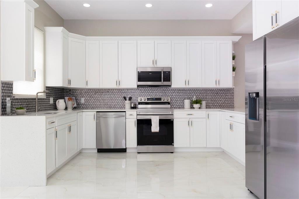 2306 Colusa Lane Valrico, FL 33596 - Photo 17 of 50 a kitchen with granite countertop white cabinets and stainless steel appliances