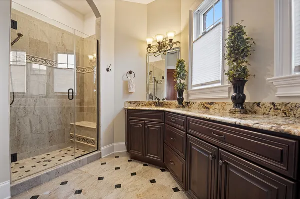a bathroom with a granite countertop sink toilet a mirror a bathtub and shower