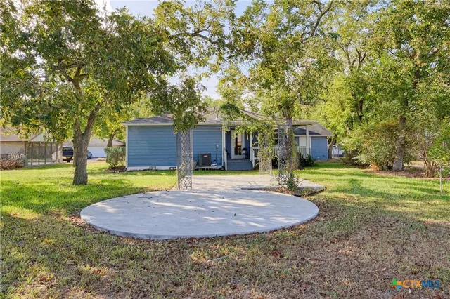 a view of a house with a yard and tree
