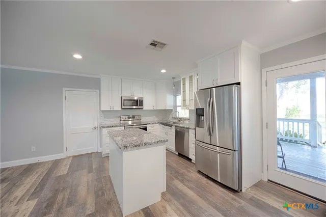 a kitchen with white cabinets and stainless steel appliances