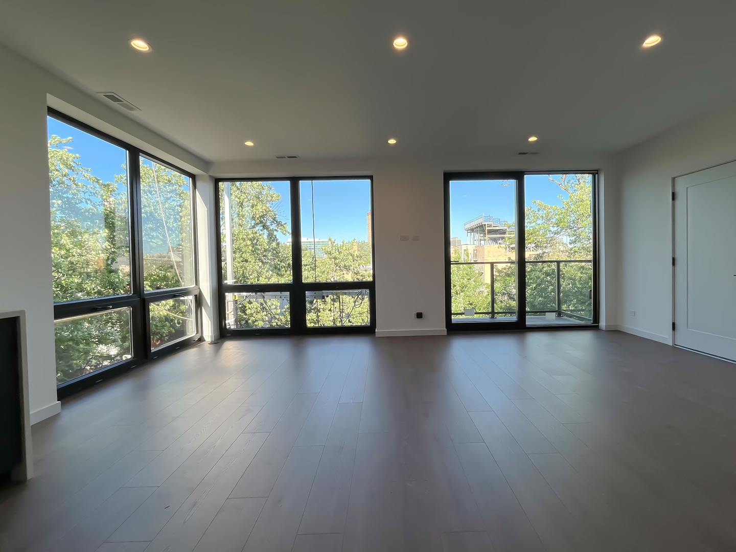 3710 North Kenmore Avenue, Unit 3 Chicago, IL 60613 - Photo 3 of 13 an empty room with large windows and wooden floor