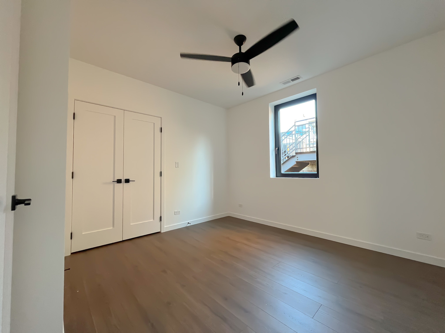 3710 North Kenmore Avenue, Unit 3 Chicago, IL 60613 - Photo 4 of 13 an empty room with wooden floor ceiling fan and windows