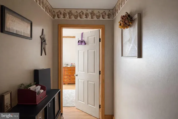 a hallway with kids room bathroom and a window