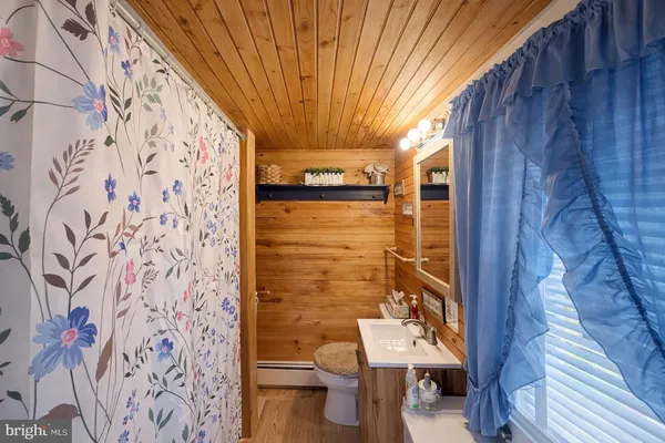 a bathroom with a toilet and a shower curtain