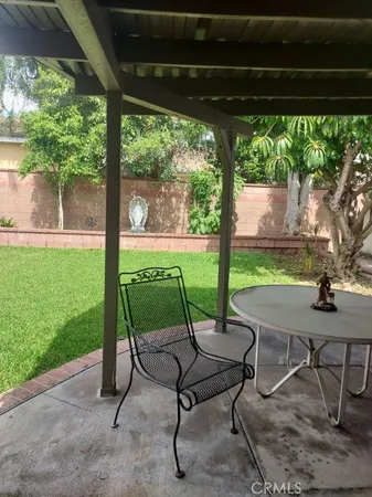 a view of a patio with a table chairs and a backyard