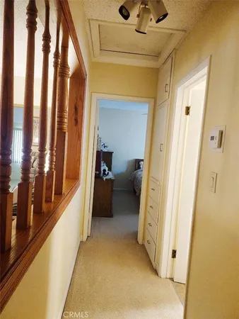 a view of a hallway with wooden floor and stairs