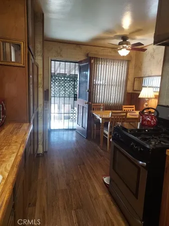 a kitchen with granite countertop a stove and wooden floor