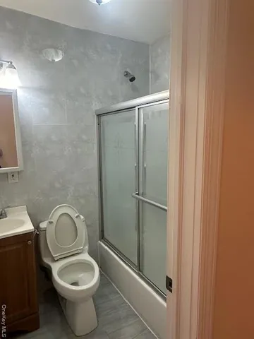 a bathroom with a granite countertop toilet and a sink