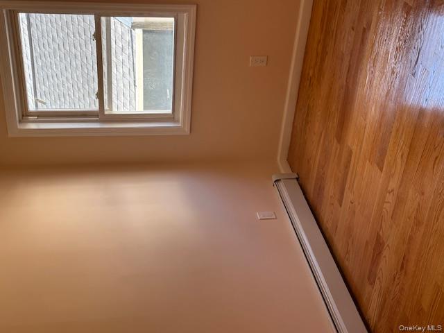 239-13 86th Avenue Queens, NY 11426 - Photo 6 of 12 Spare room with baseboard heating and light wood-style flooring