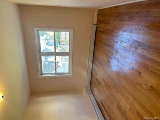 239-13 86th Avenue Queens, NY 11426 - Photo 7 of 12 Unfurnished room with light wood-type flooring and a baseboard heating unit