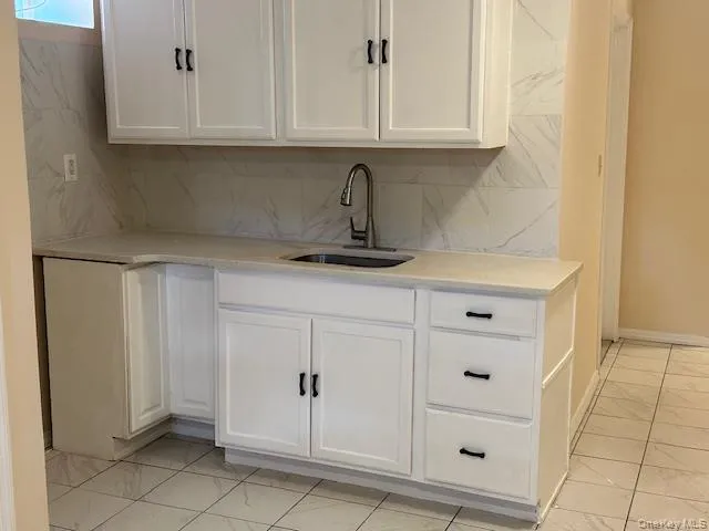 a kitchen with white cabinets and a sink