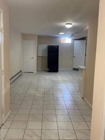 a view of a livingroom with an empty space and a refrigerator