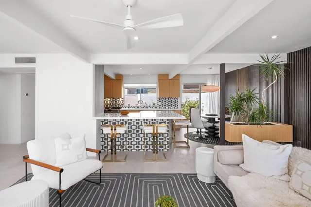 a living room with furniture a chandelier and a wooden floor