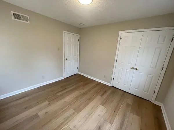 a view of an empty room with wooden floor