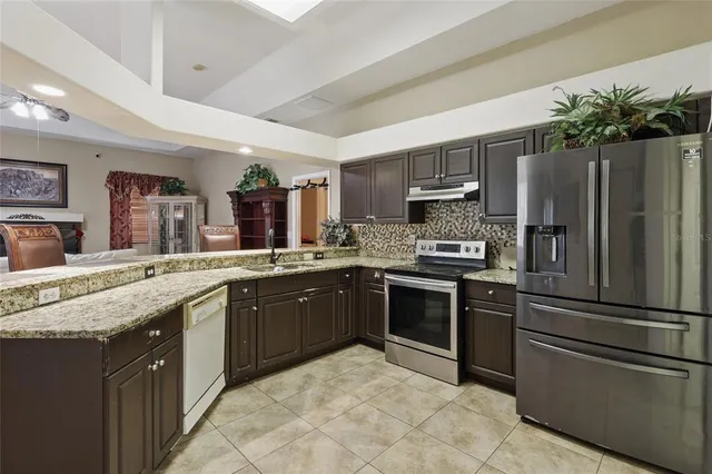 a kitchen with granite countertop stainless steel appliances and counter space