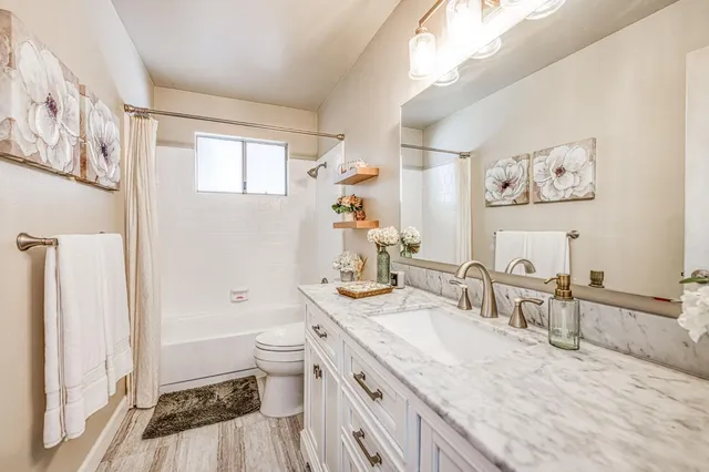 a bathroom with a granite countertop sink mirror vanity and toilet
