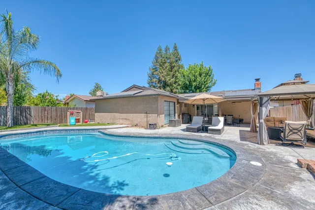 a view of a house with swimming pool and sitting area