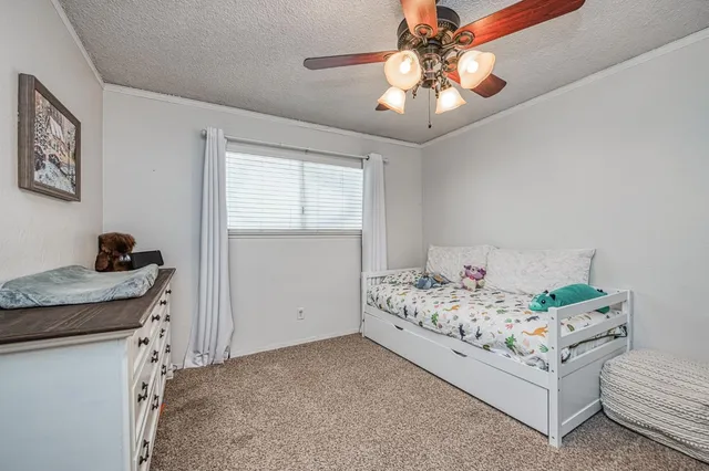 a bedroom with a bed and a chandelier fan