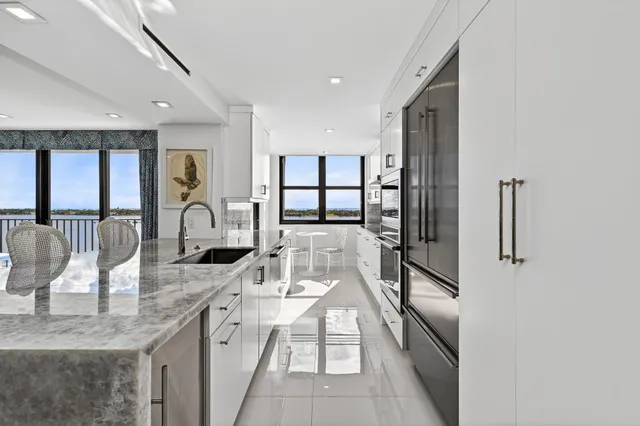 a kitchen with stainless steel appliances granite countertop a sink and a refrigerator