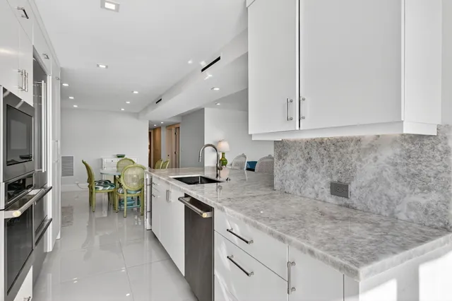 a kitchen with a sink white cabinets and stainless steel appliances
