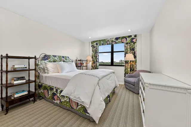 a bedroom with a bed a mirror and a window