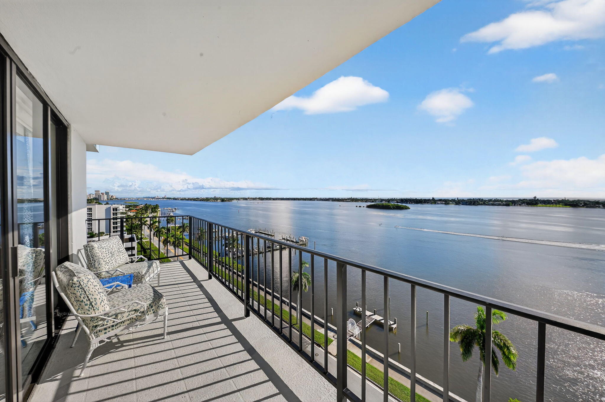 3800 Washington Road, Unit 1107 West Palm Beach, FL 33405 - Photo 7 of 49 a balcony with wooden floor and lake view