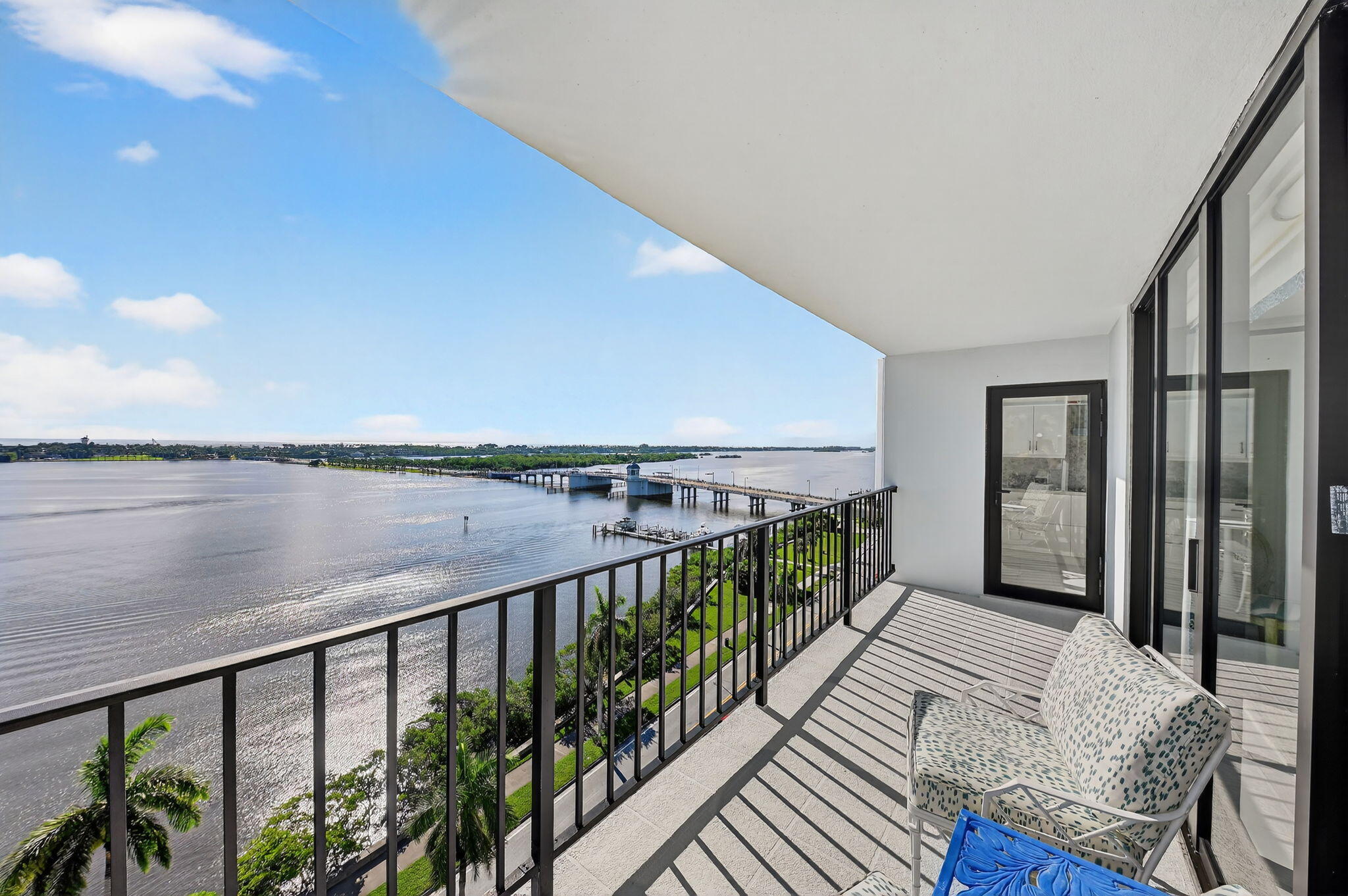 3800 Washington Road, Unit 1107 West Palm Beach, FL 33405 - Photo 9 of 49 a balcony with wooden floor and lake view
